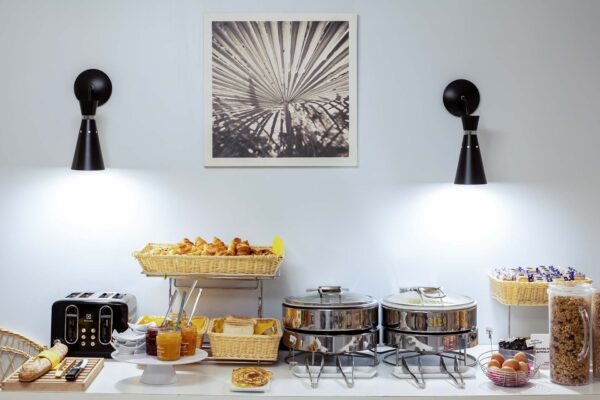 Petit-déjeuner buffet de l’Hôtel Palm à Paris avec viennoiseries, pains frais, fromages, charcuterie, yaourts, fruits frais et secs, et céréales