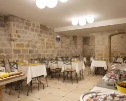 La salle de petit-déjeuner de l’Hôtel Palm offre un cadre chaleureux, idéal pour débuter la journée. Les hôtes y dégustent un buffet varié et copieux dans une ambiance conviviale et dynamique