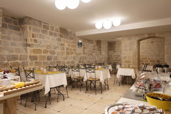 La salle de petit-déjeuner de l’Hôtel Palm offre un cadre chaleureux, idéal pour débuter la journée. Les hôtes y dégustent un buffet varié et copieux dans une ambiance conviviale et dynamique