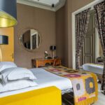 Chambre de l’Appartement Vue Jardin avec un lit, un bureau et un miroir à l’hôtel Regent’s Garden