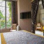 Chambre de l’Appartement Vue Jardin avec un grand lit et une télévision à écran plat à l’hôtel Regent’s Garden