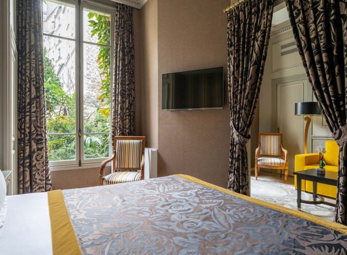 Chambre de l’Appartement Vue Jardin avec un grand lit et une télévision à écran plat à l’hôtel Regent’s Garden