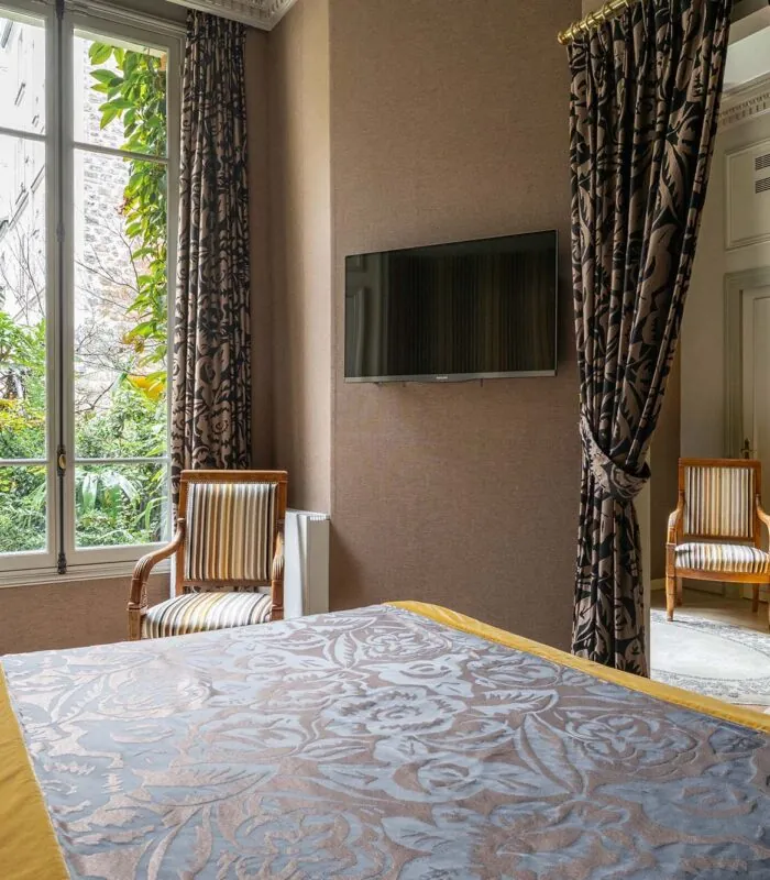Chambre de l’Appartement Vue Jardin avec un grand lit et une télévision à écran plat à l’hôtel Regent’s Garden