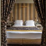 Appartement Vue Jardin avec un lit et du papier peint à rayures à l’hôtel Regent’s Garden