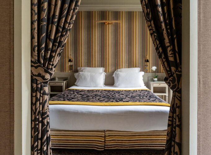 Appartement Vue Jardin avec un lit et du papier peint à rayures à l’hôtel Regent’s Garden