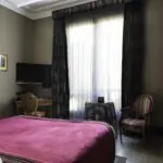 Chambre Double Supérieure avec un lit rouge et une chaise à l’hôtel Regent's Garden