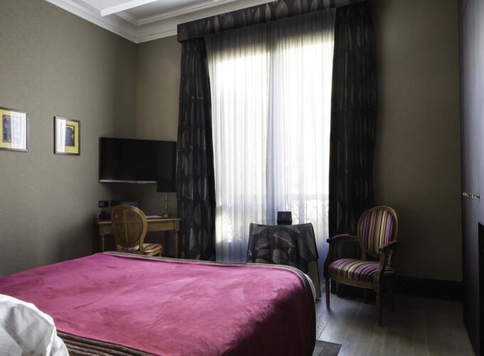 Chambre Double Supérieure avec un lit rouge et une chaise à l’hôtel Regent's Garden