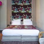 Lit de la Chambre Double Supérieure Vue Jardin avec un papier peint fleuri sur le mur à l’hôtel Regent’s Garden