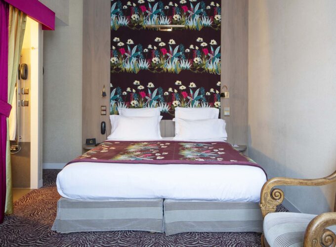 Lit de la Chambre Double Supérieure Vue Jardin avec un papier peint fleuri sur le mur à l’hôtel Regent’s Garden