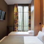 Chambre familiale supérieure vue Jardin avec deux lits et une télévision à écran plat à l’Hôtel Regent’s Garden