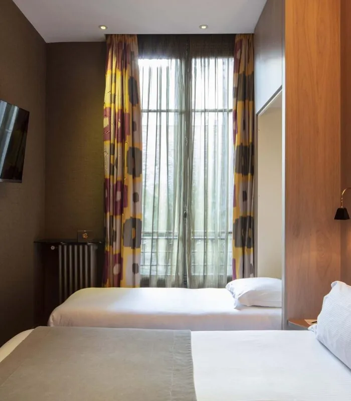 Chambre familiale supérieure vue Jardin avec deux lits et une télévision à écran plat à l’Hôtel Regent’s Garden