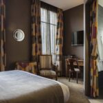 Chambre familiale supérieure vue Jardin avec un lit, une chaise, un bureau et une télévision à l’Hôtel Regent’s Garden