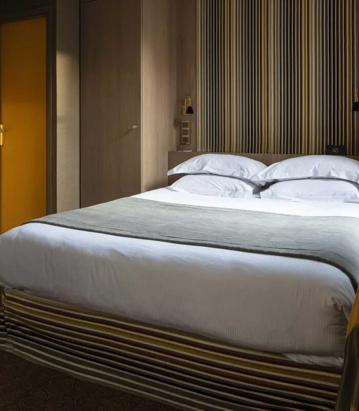 Chambre familiale supérieure vue Jardin avec un lit et une porte jaune à l’Hôtel Regent’s Garden