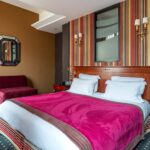 Chambre Privilège Vue Jardin avec un lit et un miroir à l’hôtel Regent’s Garden