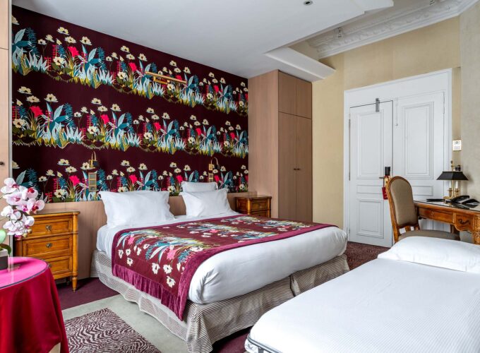 Chambre Privilège Vue Jardin avec deux lits et un bureau à l’hôtel Regent's Garden