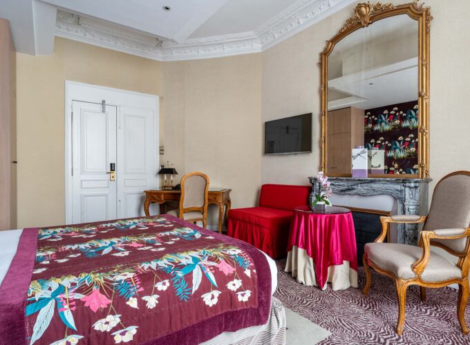 Chambre Privilège Vue Jardin avec une couverture fleurie sur le lit à l’hôtel Regent's Garden