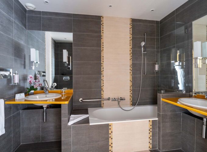 Salle de bain de la Chambre Twin Supérieure avec deux lavabos et une baignoire à l’hôtel Regent’s Garden