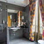 Salle de bain de la Chambre Twin Supérieure avec un lavabo et une fenêtre avec des rideaux colorés à l’hôtel Regent’s Garden