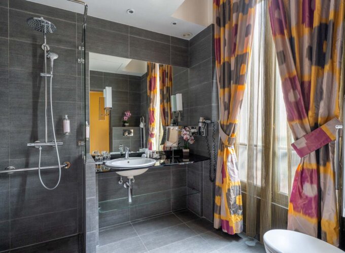 Salle de bain de la Chambre Twin Supérieure avec un lavabo et une fenêtre avec des rideaux colorés à l’hôtel Regent’s Garden