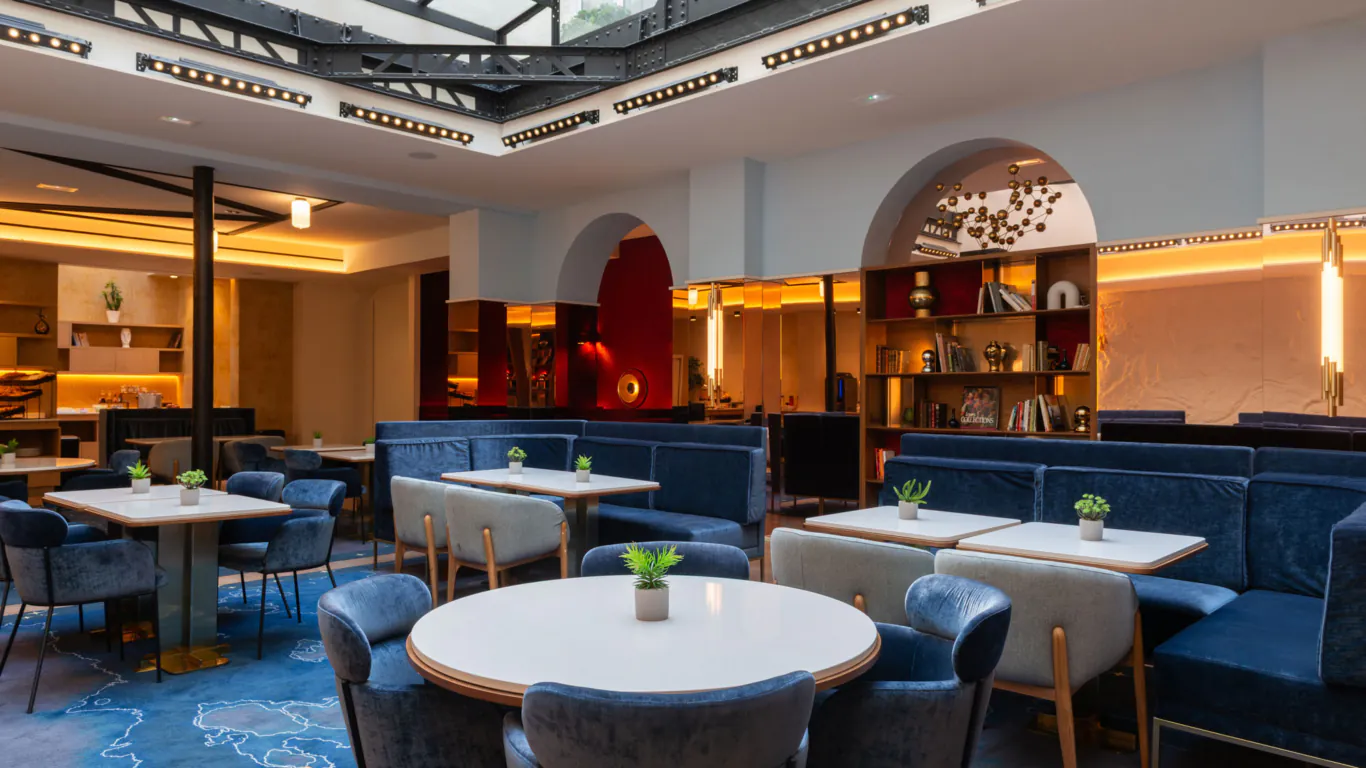 Hôtel Astra Opéra – Salle de petit-déjeuner avec des tables, des chaises et des banquettes