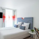 Chambre twin avec deux lits et une télévision à écran plat à l’Hôtel 34B