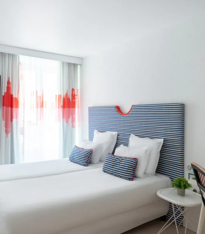 Chambre twin avec deux lits et une télévision à écran plat à l’Hôtel 34B