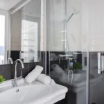 Salle de bain de la Chambre Twin à l’Hôtel 34B avec douche et lavabo.