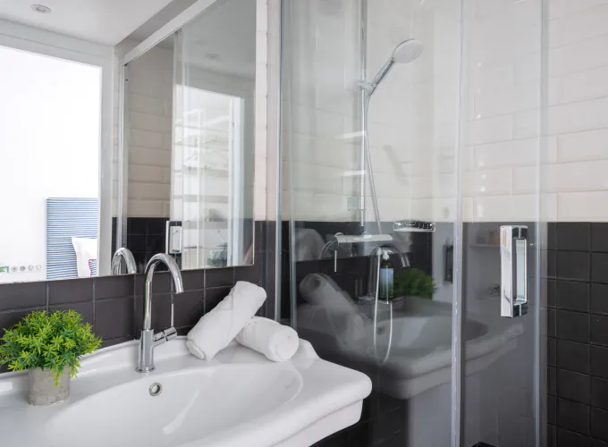 Salle de bain de la Chambre Twin à l’Hôtel 34B avec douche et lavabo.