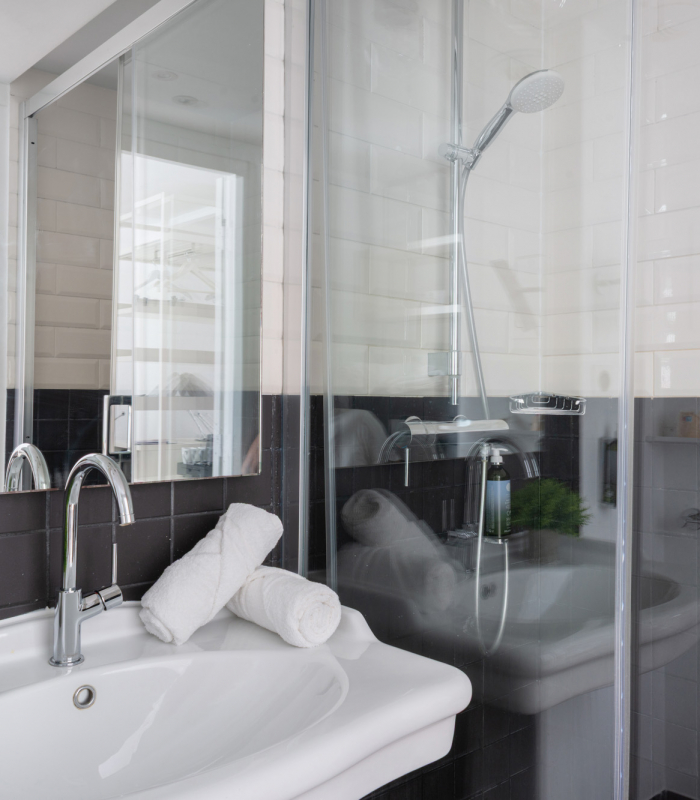 Salle de bain de la Chambre Twin à l’Hôtel 34B avec douche et lavabo.