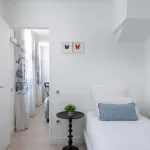 Chambre Triple à l’Hôtel 34B avec literie confortable et décoration aux tons bleus et blancs.