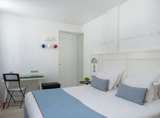 Chambre Triple à l’Hôtel 34B avec literie confortable et décoration aux tons bleus et blancs.