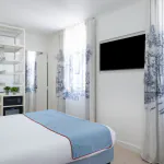 Chambre triple avec un lit et une télévision à l’Hôtel 34B