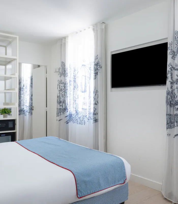 Chambre triple avec un lit et une télévision à l’Hôtel 34B