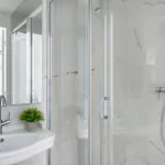 Salle de bain de la Chambre Triple à l’Hôtel 34B avec douche à l’italienne et lavabo.