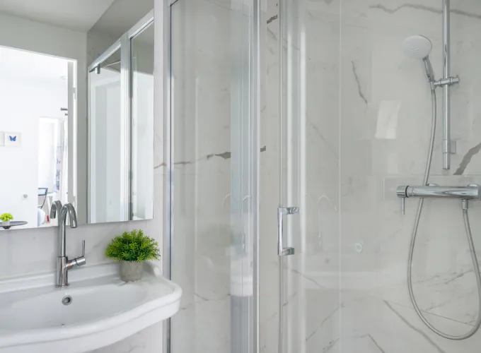 Salle de bain de la Chambre Triple à l’Hôtel 34B avec douche à l’italienne et lavabo.