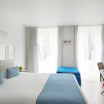 Chambre Privilège à l’Hôtel 34B avec literie confortable et décoration aux tons bleus et blancs.
