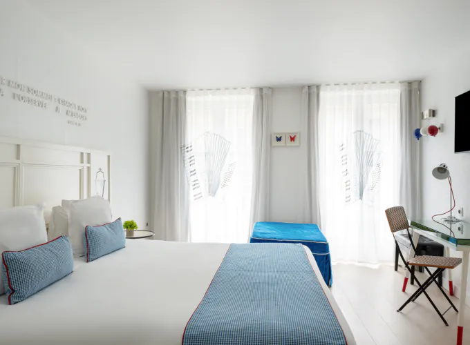 Chambre Privilège à l’Hôtel 34B avec literie confortable et décoration aux tons bleus et blancs.