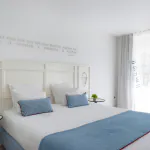 Chambre Privilège à l’Hôtel 34B avec literie confortable et décoration aux tons bleus et blancs.