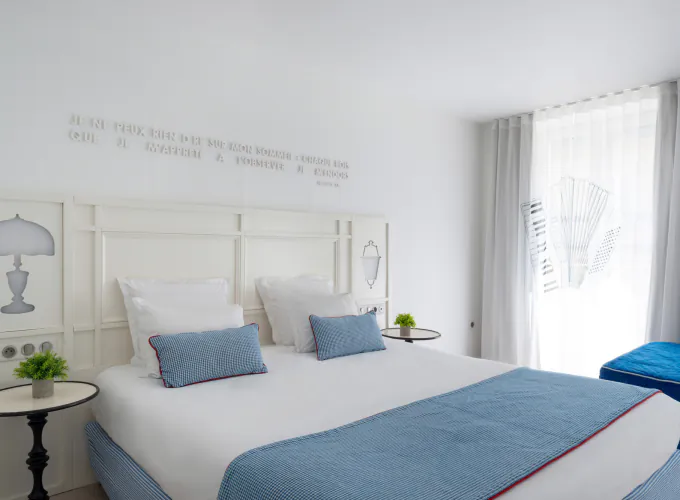Chambre Privilège à l’Hôtel 34B avec literie confortable et décoration aux tons bleus et blancs.