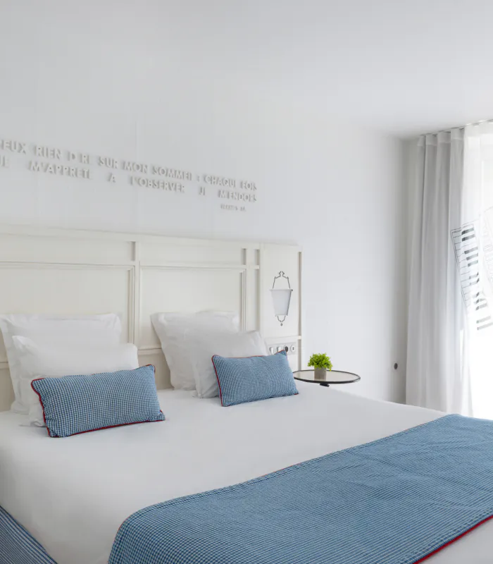 Chambre Privilège à l’Hôtel 34B avec literie confortable et décoration aux tons bleus et blancs.