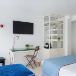 Chambre Privilège à l’Hôtel 34B avec literie confortable et décoration aux tons bleus et blancs.