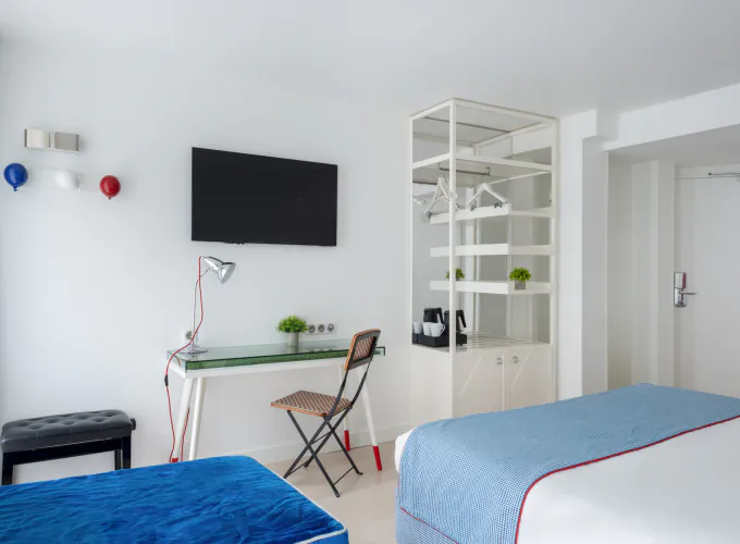 Chambre Privilège à l’Hôtel 34B avec literie confortable et décoration aux tons bleus et blancs.