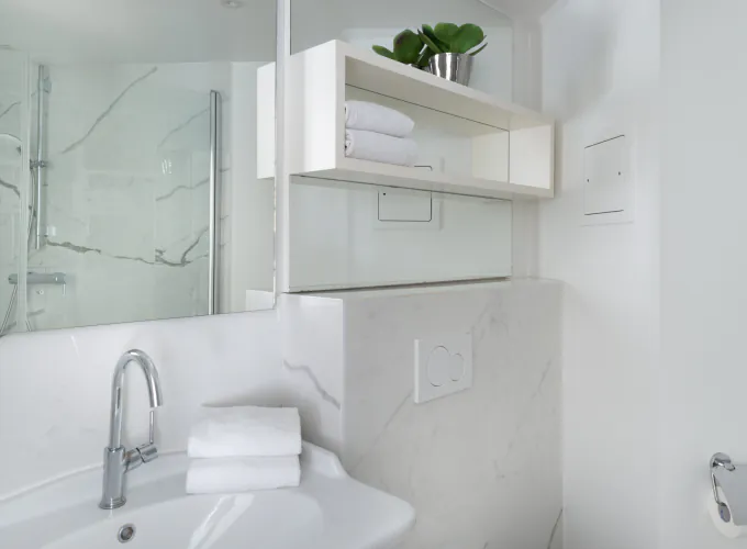 Salle de bain de la Chambre Privilège à l’Hôtel 34B avec douche et lavabo.