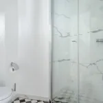 Salle de bain de la Chambre Privilège à l’Hôtel 34B avec douche et lavabo.