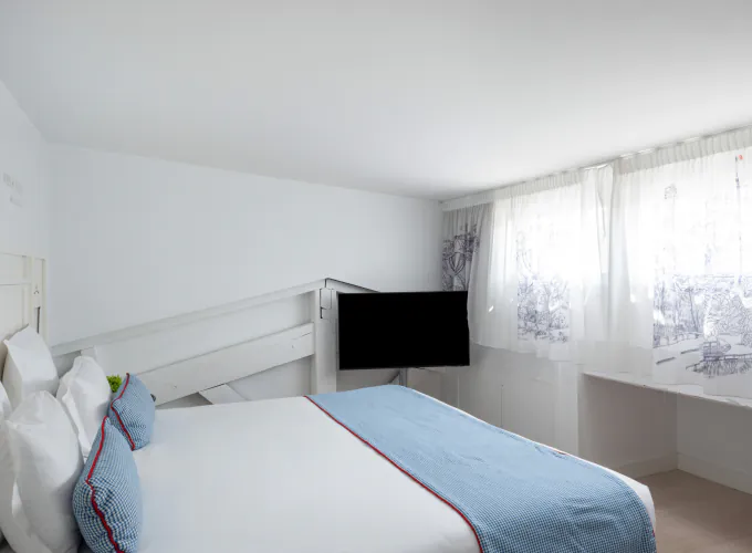 Chambre Duplex avec un lit et une télévision à l’Hôtel 34B