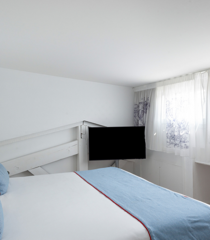 Chambre Duplex avec un lit et une télévision à l’Hôtel 34B