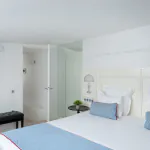 Chambre Duplex à l’Hôtel 34B avec literie confortable et décoration aux tons bleus et blancs.