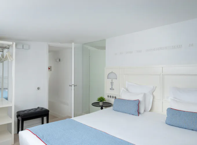 Chambre Duplex à l’Hôtel 34B avec literie confortable et décoration aux tons bleus et blancs.