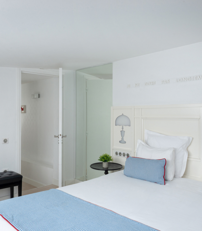 Chambre Duplex à l’Hôtel 34B avec literie confortable et décoration aux tons bleus et blancs.