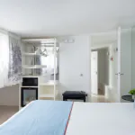 Chambre Duplex à l’Hôtel 34B avec literie confortable et décoration aux tons bleus et blancs.